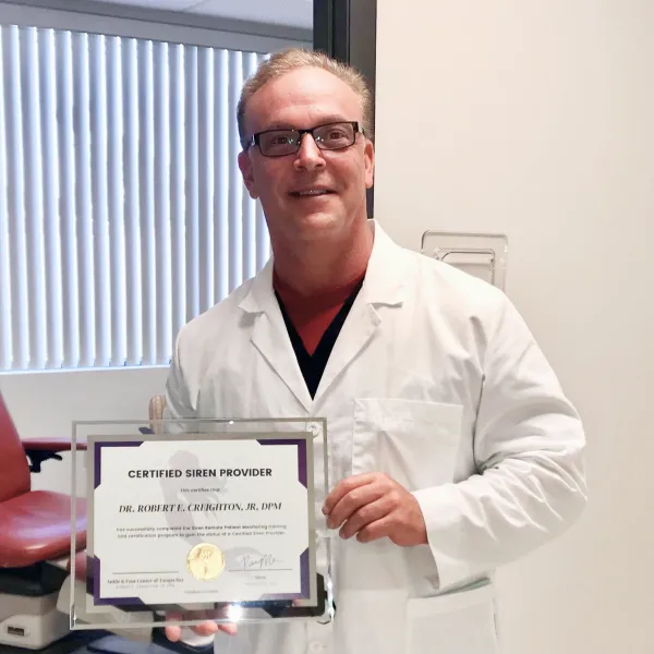 Dr. Creighton showing his certified Feetwings provider certificate.